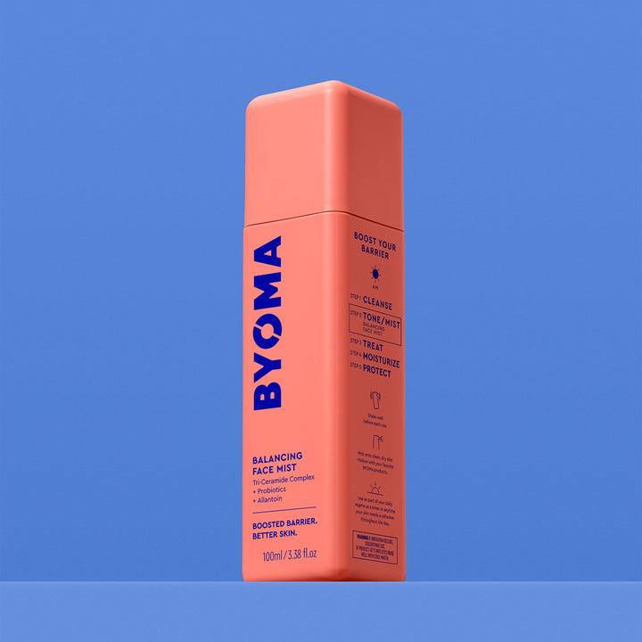 Une bouteille BYOMA Balancing Face Mist, vue en angle montrant les étapes de routine « Boost Your Barrier » sur le panneau latéral, sur fond bleu.
