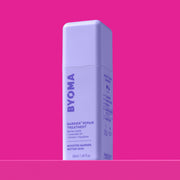 Une bouteille de traitement réparateur BYOMA Barrier+, vue en angle montrant les étapes de routine « Boost Your Barrier » sur le panneau latéral, sur fond rose.