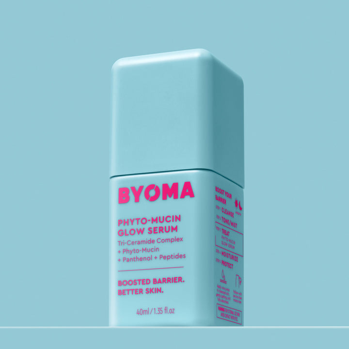 Une bouteille de Byoma Phyto-Mucin Glow Serum avec un fond bleu doux.