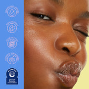 Gros plan du visage d'une personne avec application d'un produit de soin, avec logos de certification sur fond bleu et jaune.