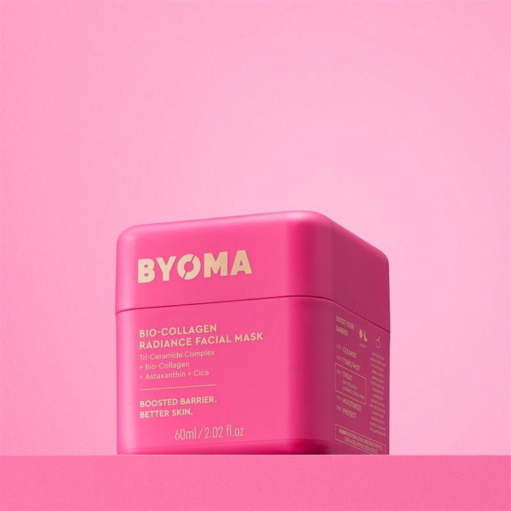 Conteneur de masque facial rose avec la marque « BYOMA » sur fond rose